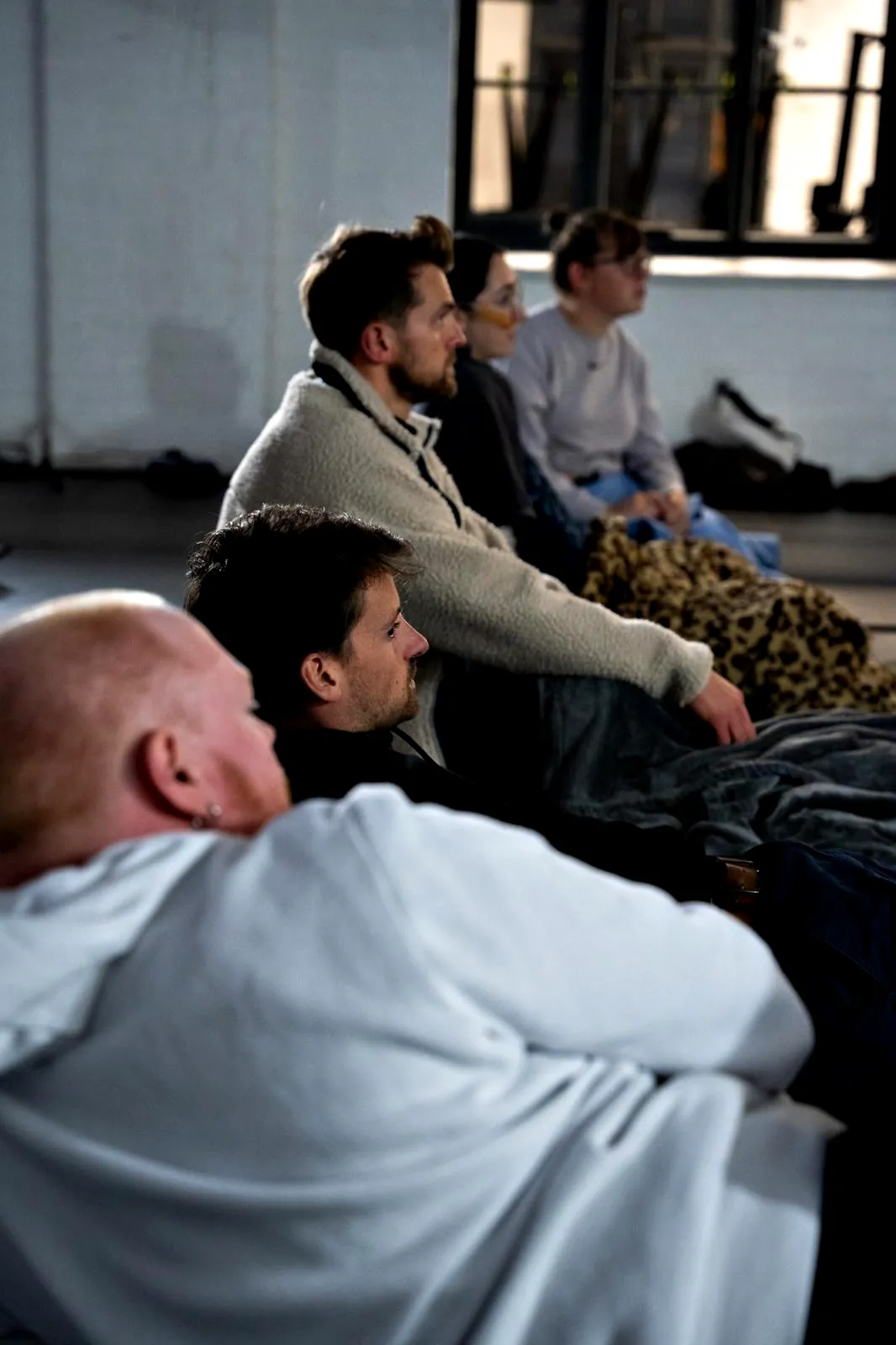 People sitting on their mats, listening before a group session begins