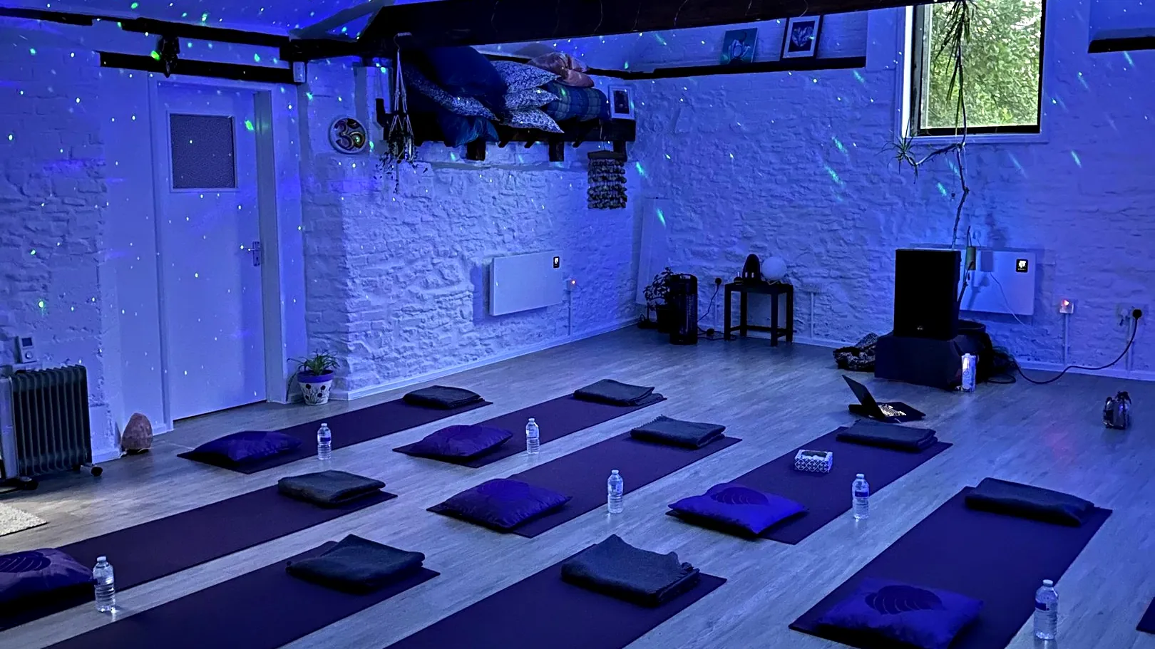 The loft studio with mats and cushions laid out before a session