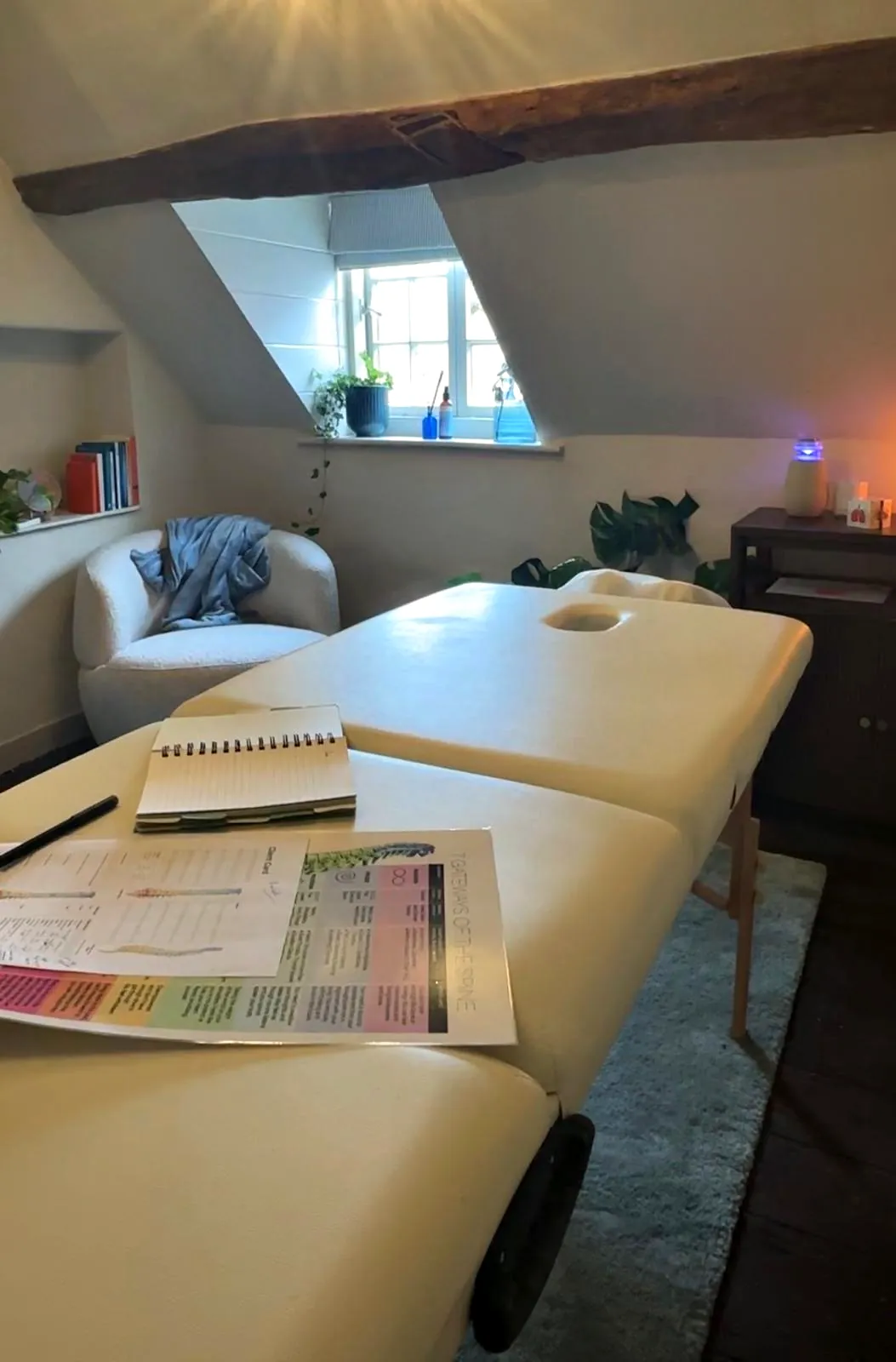The treatment couch at The Brave Studio with a notebook and the Spinal Flow gateway chart ready for a consultation