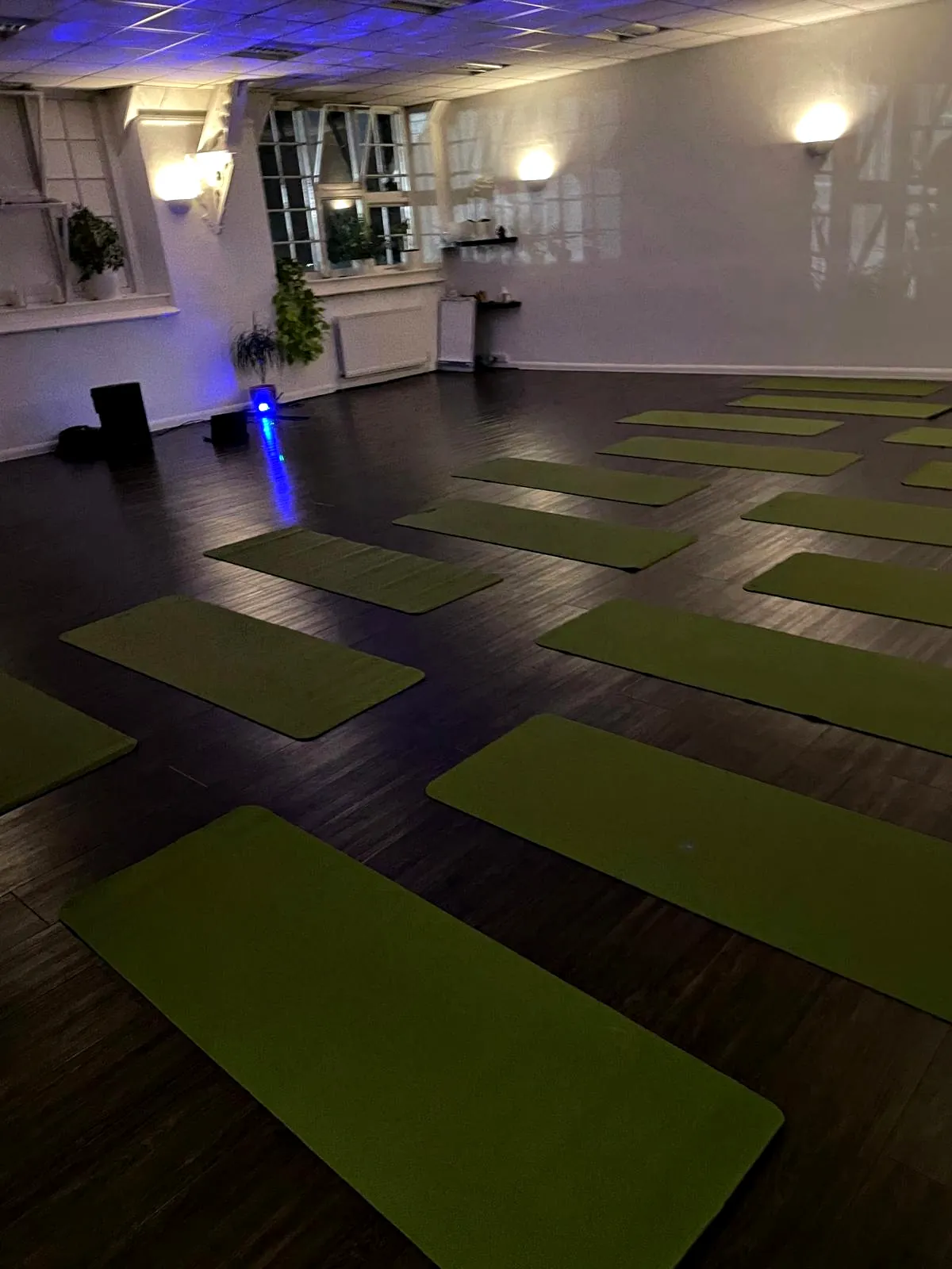 Green mats laid out in a warm studio with wall lights